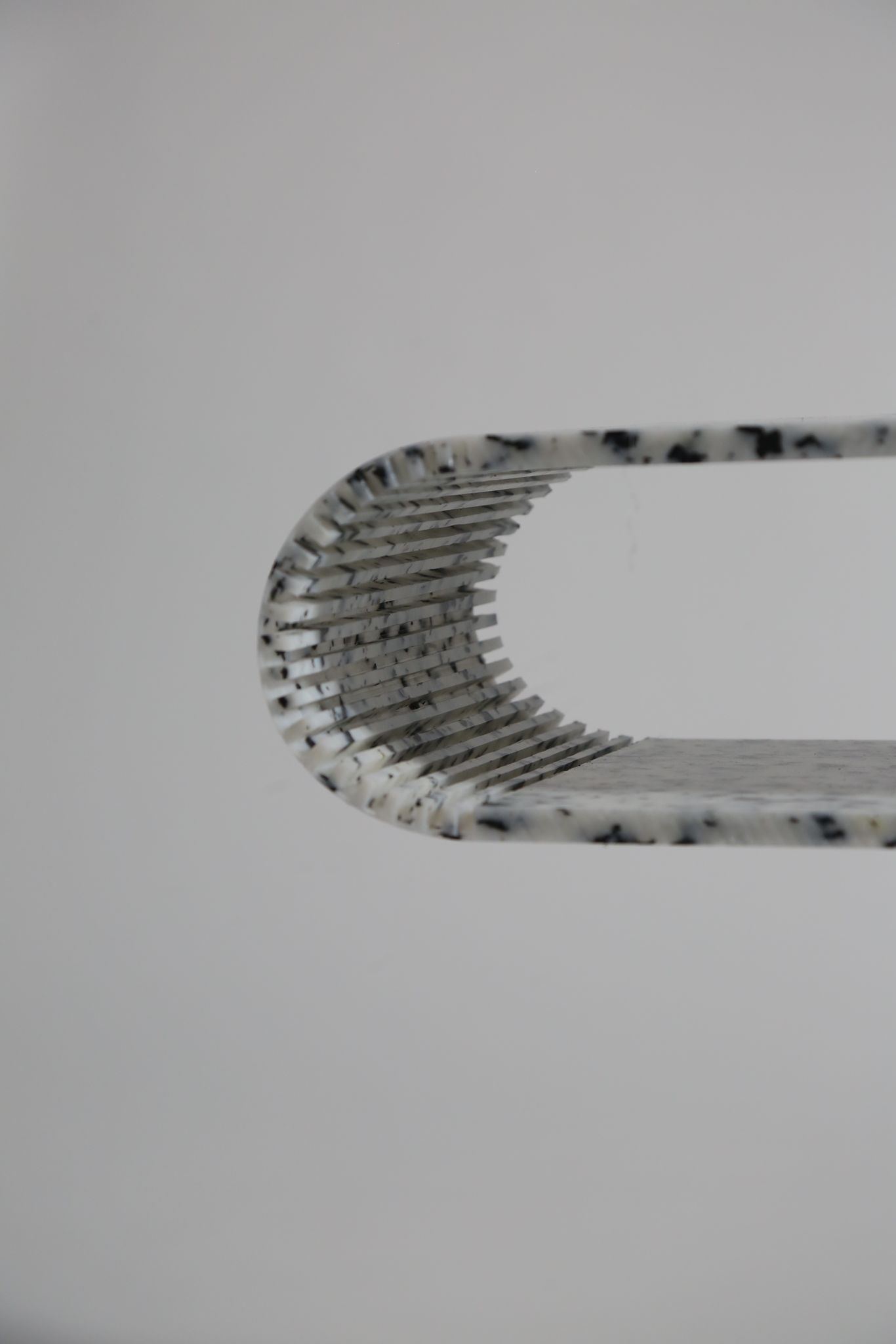 Cut at intervals, the unbendable bends — flexibility won not by force, but by subtraction.